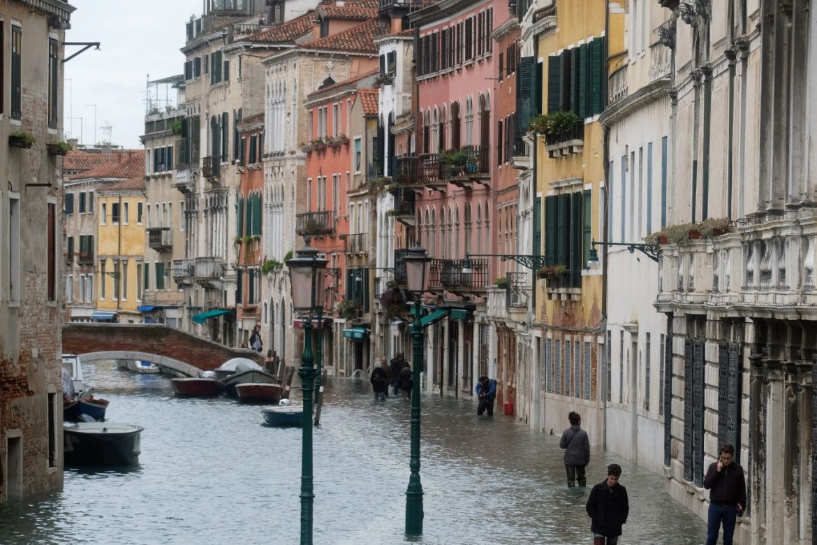 People walk in a flooded street during a period of seasonal high water in Venice Venice, Italy, November 17, 2019. REUTERS/Manuel Silvestri