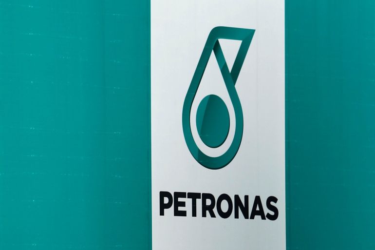 A woman passes a Petronas logo in Kuala Lumpur, Malaysia August 15, 2017. REUTERS/Lai Seng Sin