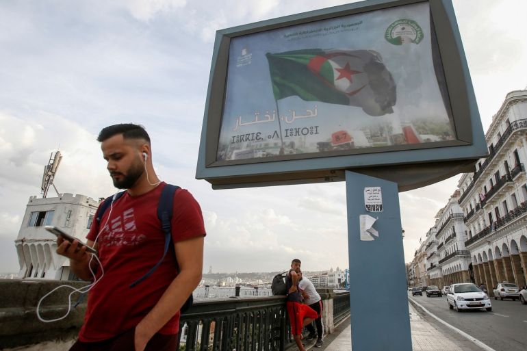 A man walks past a campaign billboard for presidential election in Algiers, Algeria November 2, 2019. The billboard reads: