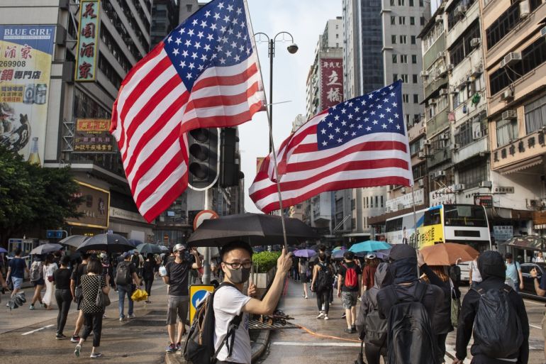 Anti-Government Protests Continue in Hong Kong- - HONG KONG, CHINA - OCTOBER 12 : Protesters wave United States flag during an anti-emergency law march in Tsim Sha Tsui, Hong Kong on October 12, 2019. Despite the face mask ban and subsequently arrests, protesters have continued to march the streets of Kowloon district following a violent weekend of unrest which also crippled the city's train network.