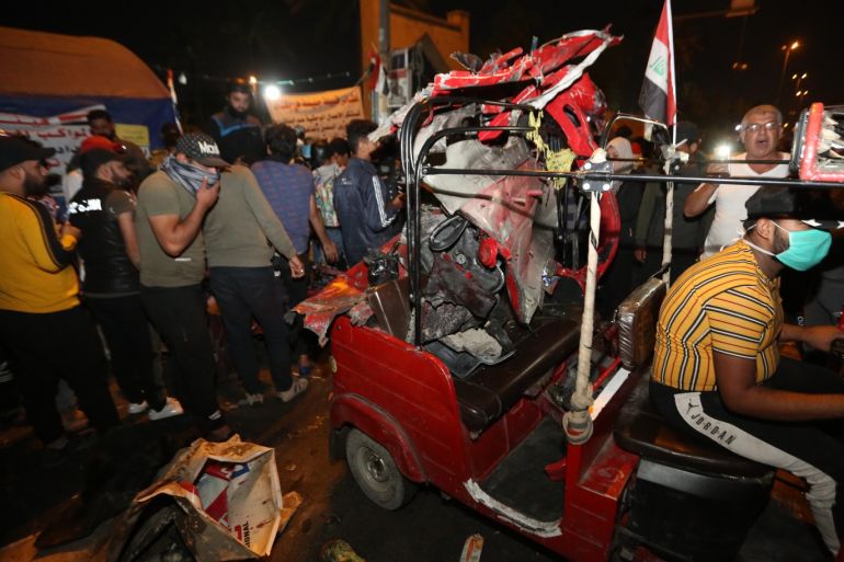 4 killed in bomb attack in Iraq’s Tahrir square- - BAGHDAD, IRAQ - NOVEMBER 15 : Locals remove the parts of a damaged vehicle after a car bomb attack targeted Tahrir Square in Iraq's Baghdad amid anti-government protests ongoing since October, on November 15, 2019. At least four people were killed and 20 injured in the attack.