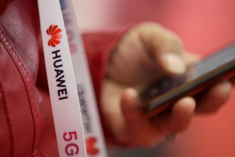 An attendee wears a badge strip with the logo of Huawei and a sign for 5G at the World 5G Exhibition in Beijing, China November 22, 2019. REUTERS/Jason Lee