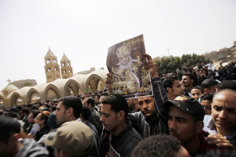 CAIRO, EGYPT- MARCH 20: A poster is held aloft as Egyptian Christians mourn at the funeral of Pope Shenouda III, the head of Egypt's Coptic Orthodox Church, in the Abassiya Cathedral March 20, 2012 in Cairo, Egypt. Thousands of mourners gathered in Cairo for the funeral of Egypt's Orthodox Christian Pope Shenouda. (Photo by Salah Malkawi/ Getty Images)