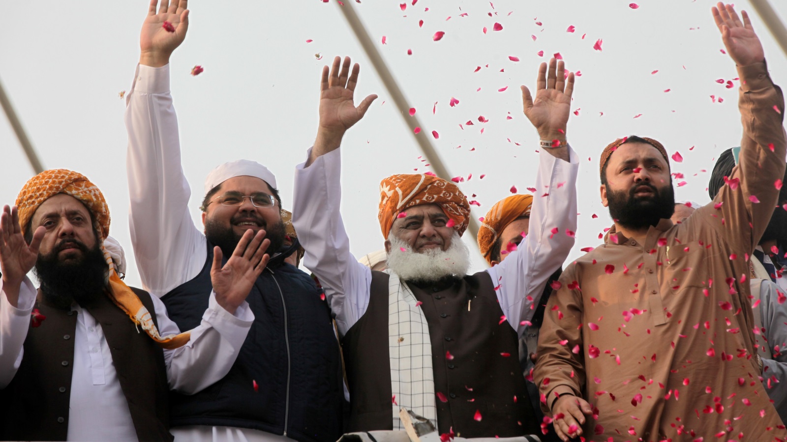 ‪فضل الرحمن (الثاني من اليمين) يلوح لأنصاره في مدينة لاهور‬  (رويترز)
