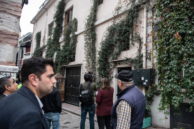 ISTANBUL, TURKEY - NOVEMBER 11: TV journalist report from the crime scene as people stand and watch in front of the sealed entrance of a home reportedly belonging to James Le Mesurier, where his body was found dead in the early hours of this morning on November 11, 2019 in the Karakoy district of Istanbul, Turkey. Le Mesurier, a former British army officer, founded Mayday Rescue, a non-profit group that helped organize Syrian volunteer first responders known as the Whit