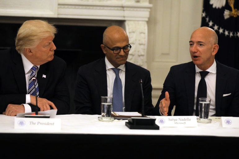 U.S. President Donald Trump and Satya Nadella, CEO of Microsoft Corporation listen as Jeff Bezos, CEO of Amazon speaks during an American Technology Council roundtable at the White House in Washington, U.S., June 19, 2017. REUTERS/Carlos Barria