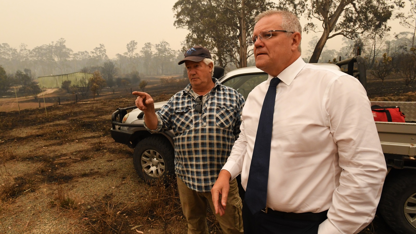 ‪(غيتي)‬ رئيس الوزراء الأسترالي أثناء تفقده ما خلفته الحرائق يوم أمس الجمعة 
