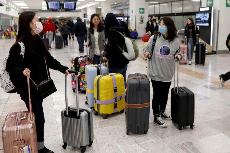 Tourists wearing protective masks arrive on a Hainan Airlines flight from Beijing at Benito Juarez international airport in Mexico City, Mexico January 24, 2020. REUTERS/Carlos Jasso