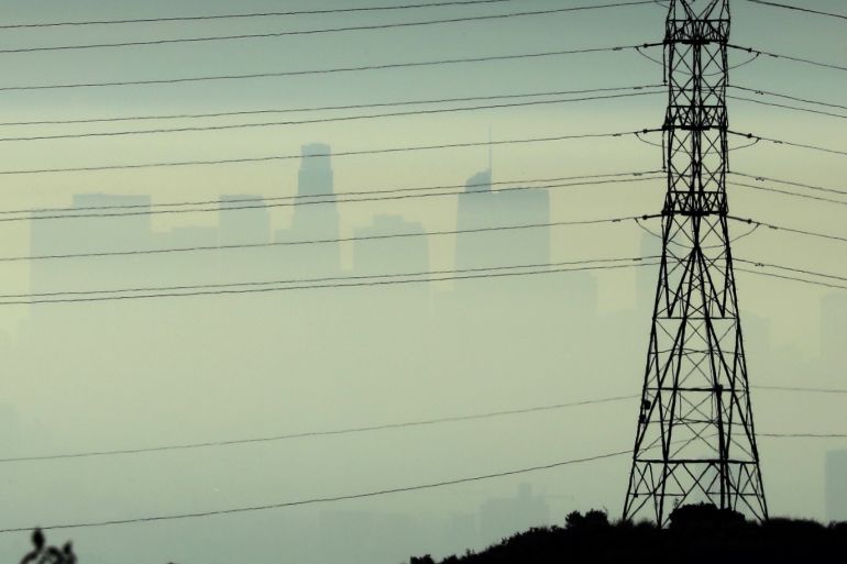 Downtown Los Angeles is seen behind an electricity pylon through the morning marine layer in Los Angeles, California, U.S., August 20, 2019. REUTERS/Lucy Nicholson