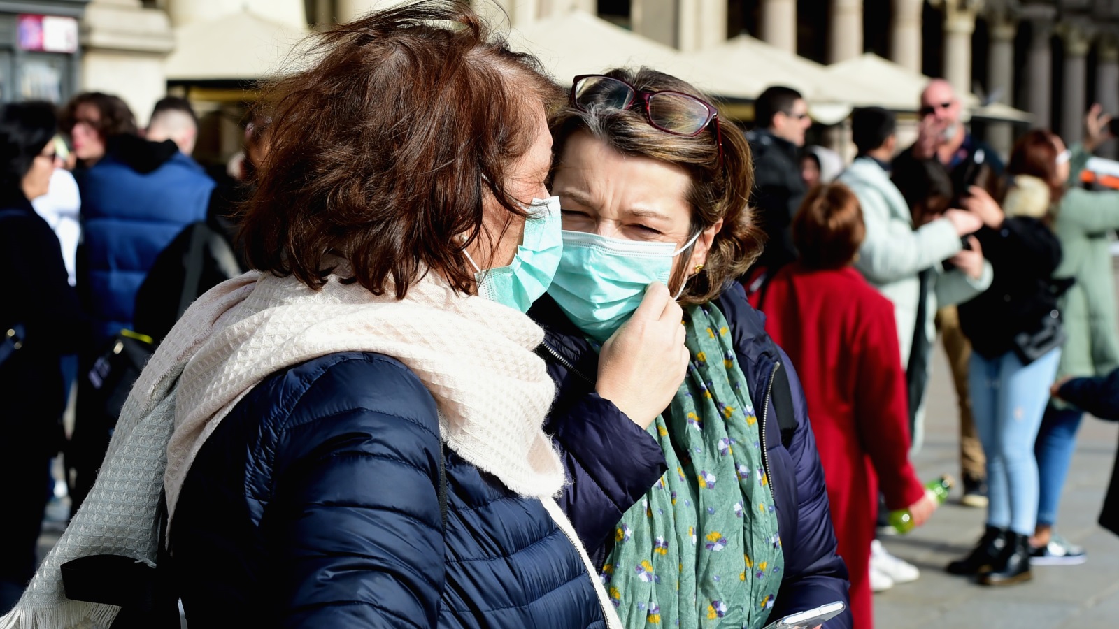 ‪سيدتان تضعان قناعين في مدينة ميلانو بإيطاليا التي تشهد تفشيا لفيروس كورونا‬ (الأناضول)