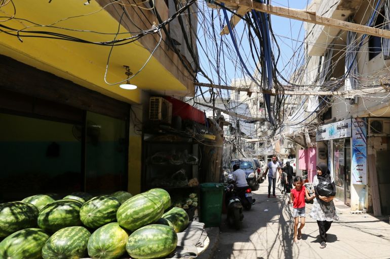 People walk along a street covered with electricity cables at Burj al-Barajneh refugee camp in Beirut, Lebanon, June 24, 2019. REUTERS/Aziz Taher