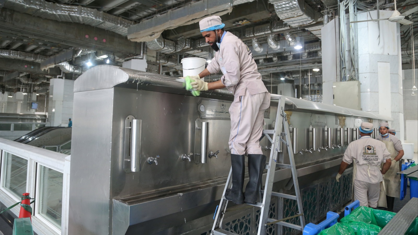 ‪العمال ينظفون برادات ماء زمزم في مكة المكرمة‬  (رويترز)