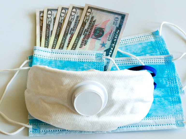 Medical masks and 50 dollars bills as a symbol of increased prices for protecting the respiratory tract from viruses.