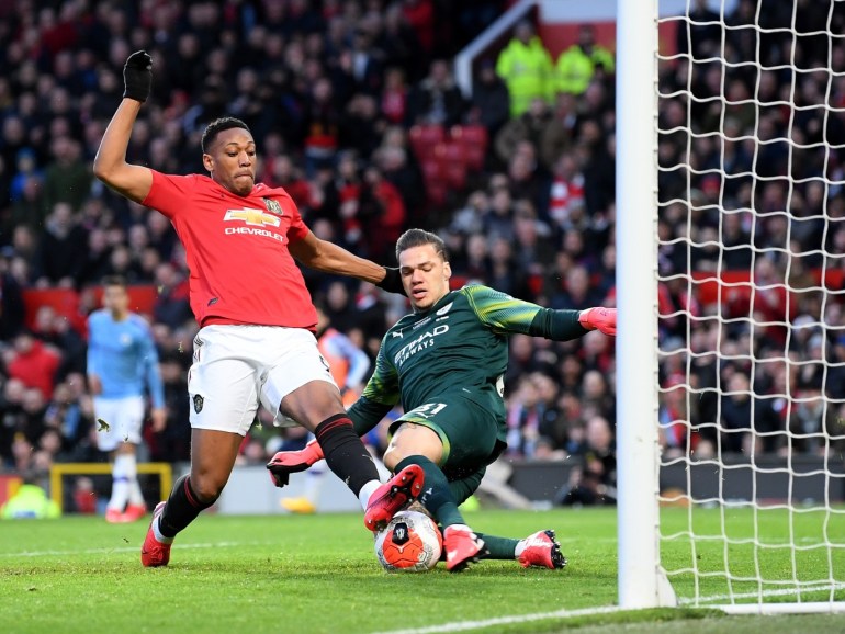 MANCHESTER, ENGLAND - MARCH 08: Ederson of Manchester City clears the ball and collides with Anthony Martial of Manchester United during the Premier League match between Manchester United and Manchester City at Old Trafford on March 08, 2020 in Manchester, United Kingdom. (Photo by Laurence Griffiths/Getty Images)
