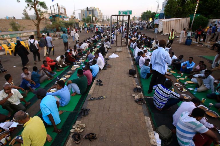 Sudanese protesters share an Iftar meal as they continue to gather outside the military headquarters in the capital Khartoum demanding the instalment of civilian rule, on May 22, 2019, during the Muslim holy fasting month of Ramadan. - Thousands of Sudanese men and women have held an around-the-clock sit-in at the site since April 6, initially to seek the military's support in toppling longtime autocrat Omar al-Bashir and later to remove the generals who seized power after his ouster. (Photo by ASHRAF SHAZLY / AFP)