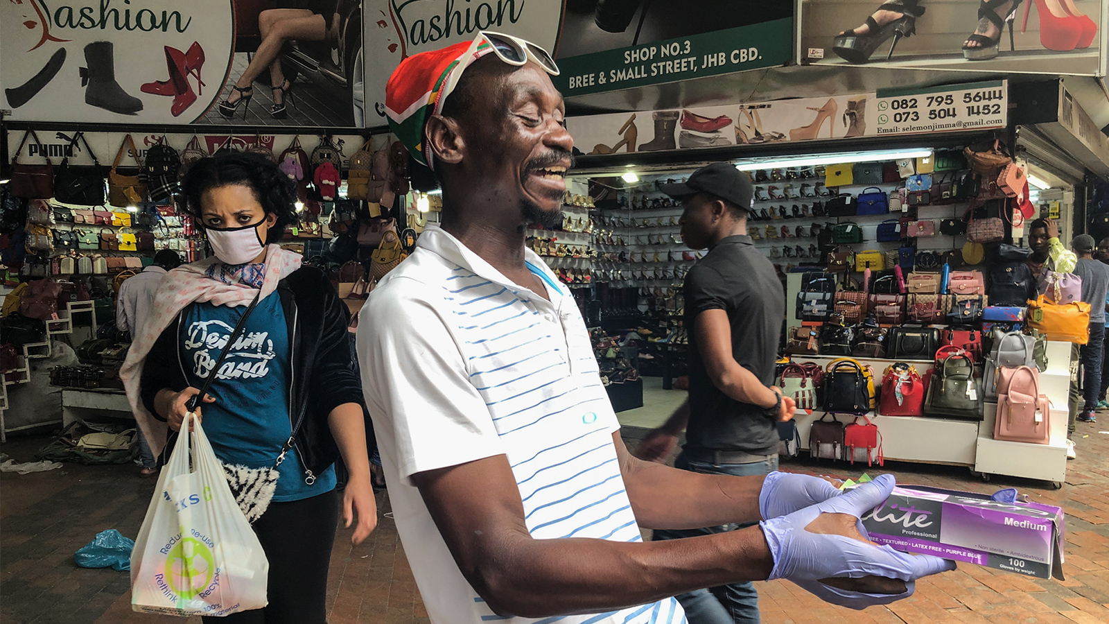 بائع متجول وسط مدينة جوهانسبورغ يبيع مستلزمات طبية للناس في الشارع (الجزيرة)