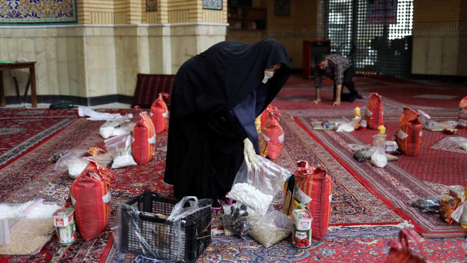 إيرانية تجهز مواد غذائية لتوزيعها على الفقراء والمعوزين في طهران (رويترز)