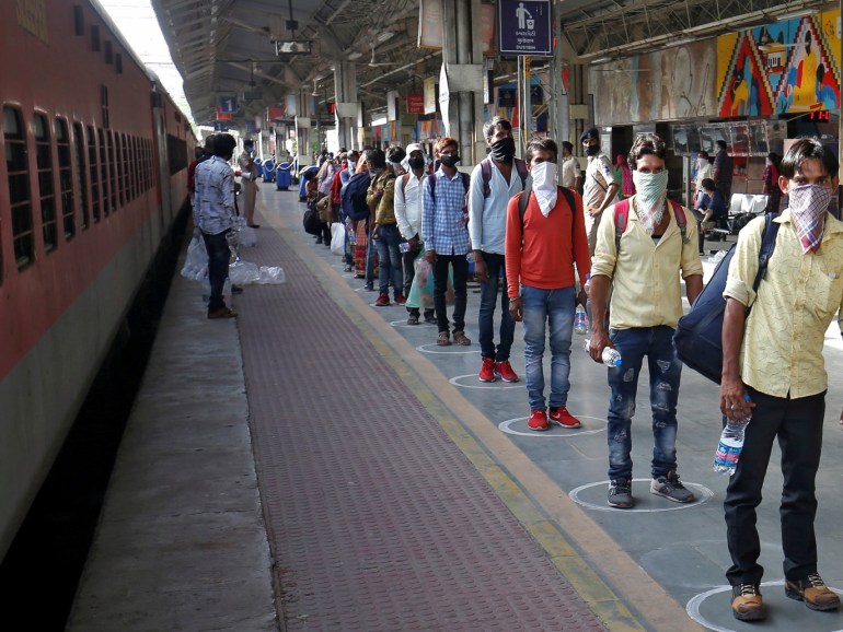 Migrant workers, who were stranded in the western state of Gujarat due to a lockdown imposed by the government to prevent the spread of coronavirus disease (COVID-19), maintain social distance as they stand in a queue to board a train that will take them to their home state of northern Uttar Pradesh, in Ahmedabad, India, May 5, 2020. REUTERS/Amit Dave