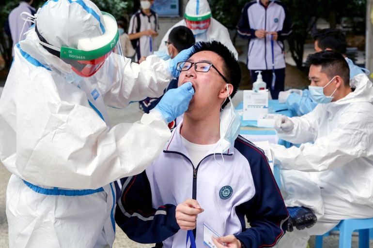 Workers in protective suits collect swabs from senior high school students for nucleic acid tests at Hubei Wuchang Experimental High School before the students are set to return to campus on May 6, in Wuhan, the Chinese city hit hardest by the coronavirus disease (COVID-19) outbreak, in China's Hubei province April 30, 2020. cnsphoto via REUTERS ATTENTION EDITORS - THIS IMAGE WAS PROVIDED BY A THIRD PARTY. CHINA OUT.