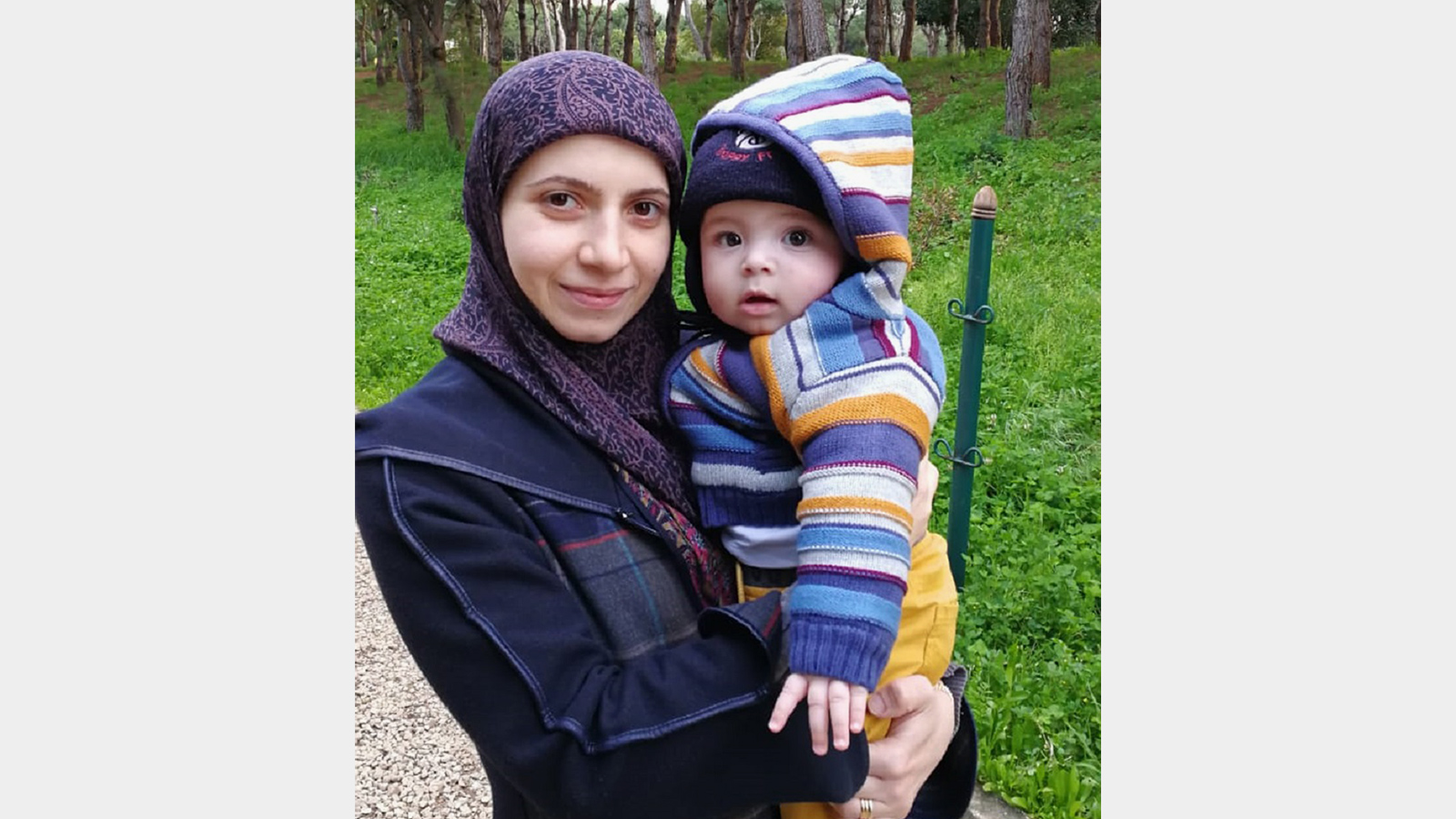 ‪زينب تحتضن طفلها جعفر الذي تغيب عنه ثلاث ليال في رمضان بسبب دوامها الليلي‬ (الجزيرة)