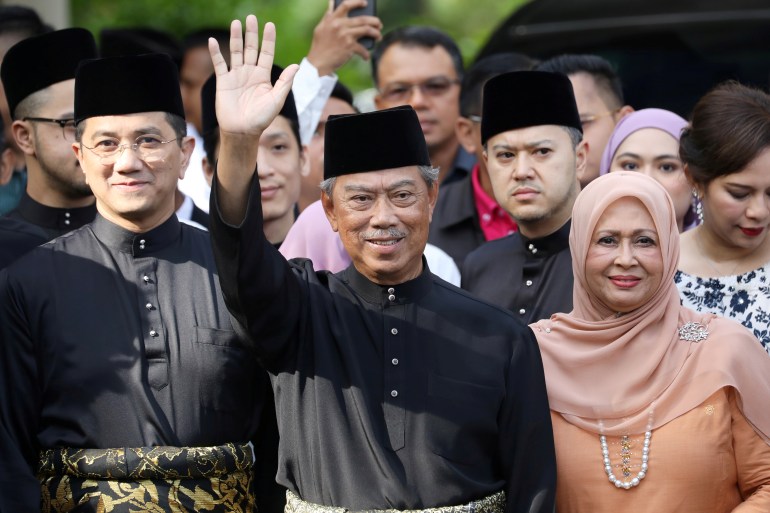Malaysia's Prime Minister Designate and former interior minister Muhyiddin Yassin waves to reporters before his inauguration as the 8th prime minister, outside his residence in Kuala Lumpur