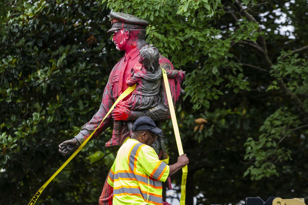 عمال يزيلون تمثال الشرطة التذكاري في ريتشموند بولاية فيرجينيا بعد أن صبغه المتظاهرون باللون الأحمر.