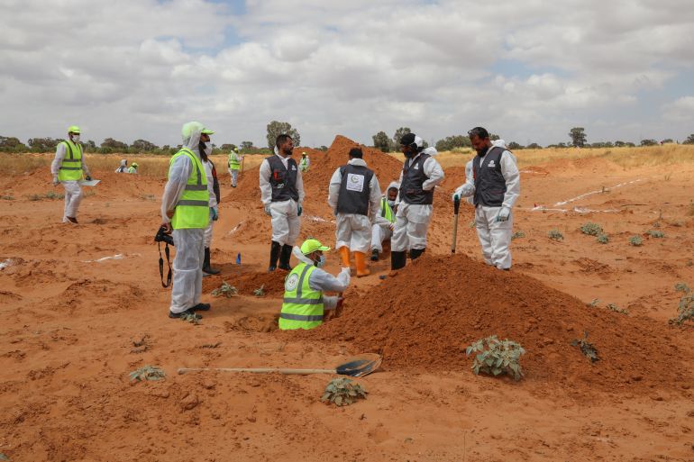 Members of the Government of National Accord's (GNA's) missing persons bureau search for human remains in what Libya's internationally recognized government officials say is a mass grave, in Tarhouna city