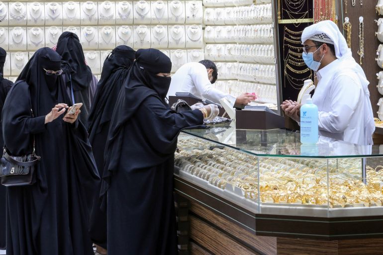 Saudi women buy jewellery at a shop in the gold market before the expected increase of VAT to 15%, in Riyadh