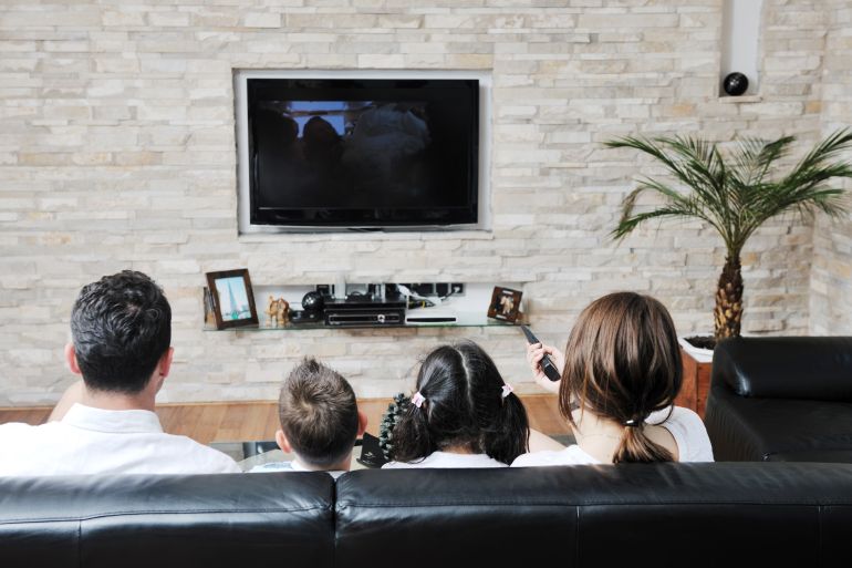 happy young family wathching flat tv at modern home indoor; Shutterstock ID 79170475; Department: -