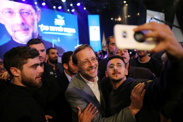 Moshe Feiglin, leader of Zehut, an ultra-nationalist religious party, poses for a selfie with supporters at an election campaign event in Tel Aviv, Israel