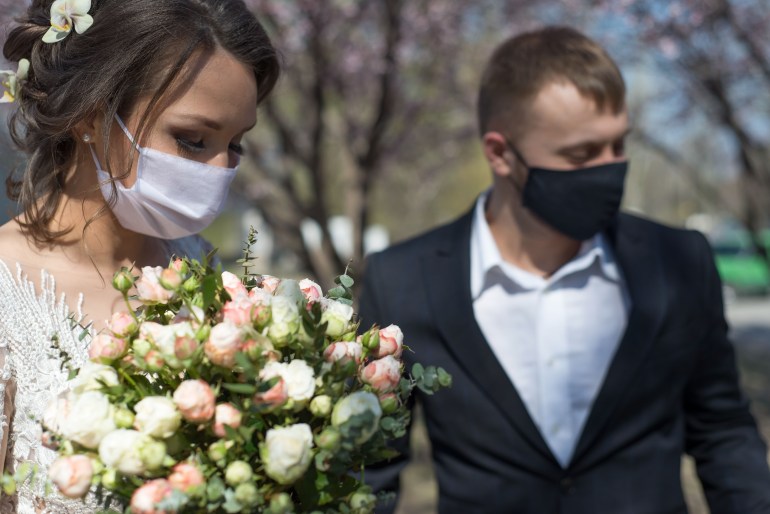 bride and groom in protective masks. Wedding during the period of quarantine and pandemic Covid 19-20, coronavirus wedding. The groom and the bride in wedding dresses, with dresses in protective masks; Shutterstock ID 1748008373; Department: -