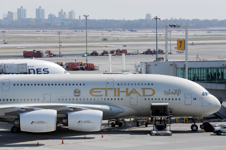 An Etihad plane stands parked at a gate at JFK International Airport in New York