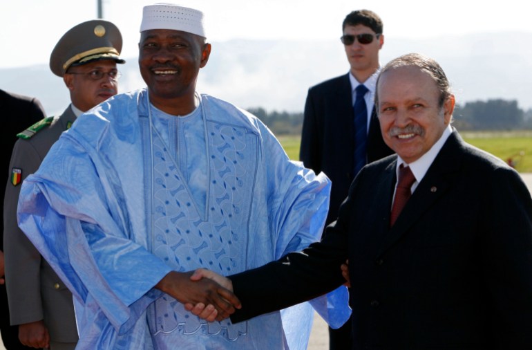 Algeria's President Abdelaziz Bouteflika shakes hands with his Malian counterpart Amadou Toumani Toure upon his arrival at Algiers