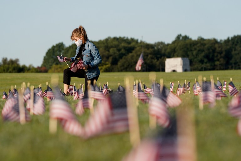 American flags representing 200,000 lives lost due to coronavirus are placed on National Mall in Washington