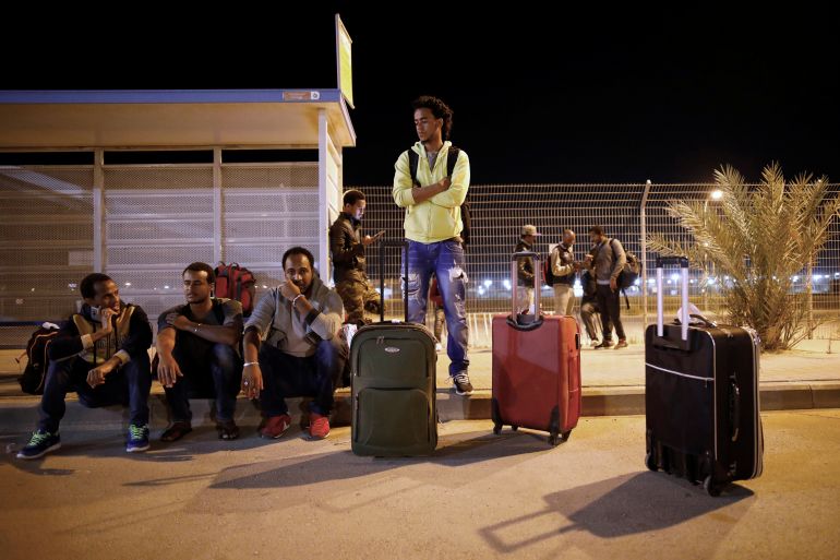 African migrants wait for a bus after being released from Saharonim Prison in the Negev desert