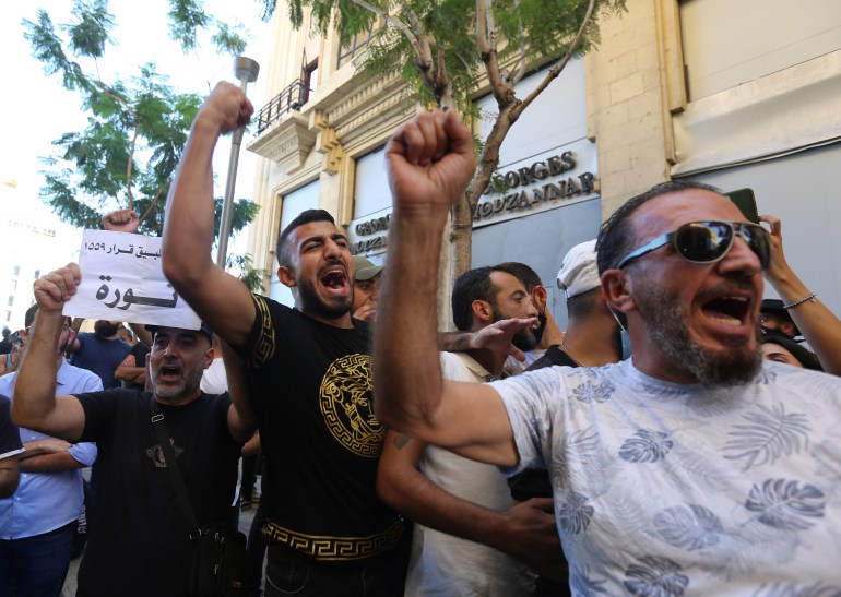 Anti-government demonstrators chant slogans and gesture during a protest as Lebanese mark one year since the start of nation-wide protests in Beirut