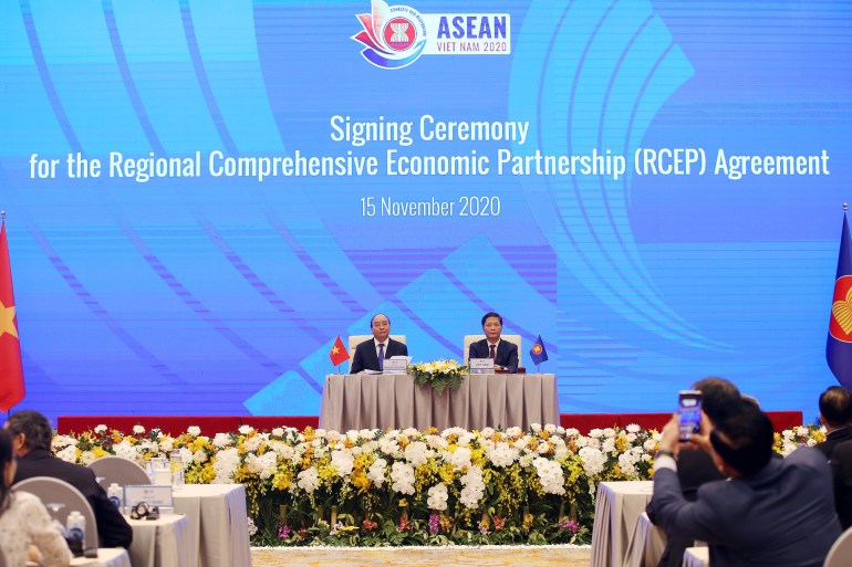 epa08821143 Vietnam's Prime Minister Nguyen Xuan Phuc (L) and Minister of Industry and Trade Tran Tuan Anh (R) during the virtual signing ceremony for the Regional Comprehensive Economic Partnership (RCEP) in Hanoi, Vietnam, 15 November 2020. The...