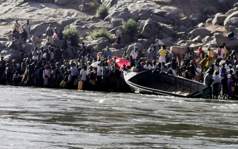 Ethiopians who fled the ongoing fighting in Tigray region prepare to cross the Setit River on the Sudan-Ethiopia border in Hamdait village in eastern Kassala state