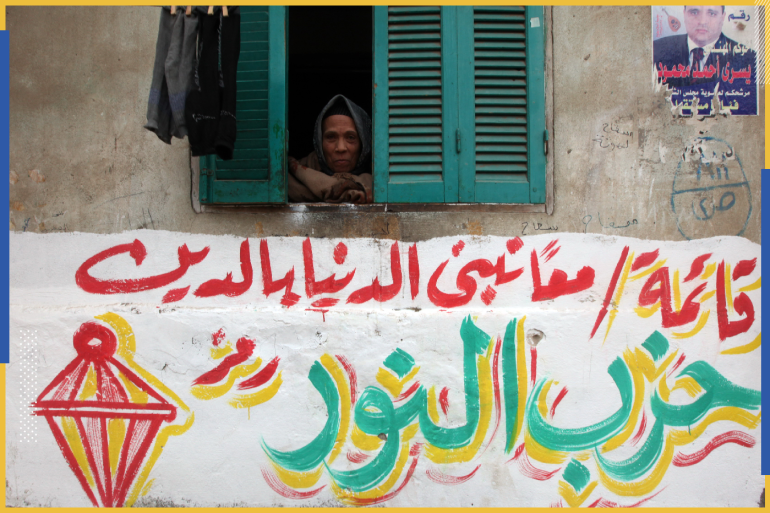A woman looks through her window above an electoral slogan for Salafi political party Al-Nour that reads, "Together hand in hand we build the country through religion" , outside a polling station in Toukh, El-Kalubia governorate, about 25 km (16 miles) northeast of Cairo January 3, 2012. Egyptians voted in the third round of a parliamentary election on Tuesday that has so far handed Islamists the biggest share of seats in an assembly that will be central in the planned transition from army rule. REUTERS/Amr Abdallah Dalsh (EGYPT - Tags: POLITICS ELECTIONS)