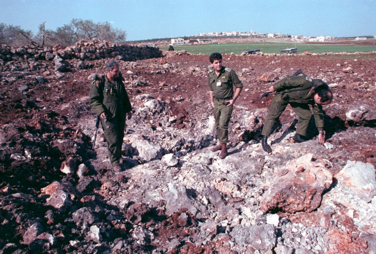 ISRAELI SOLDIERS STAND IN CRATER AFTER SCUD ATTACK.