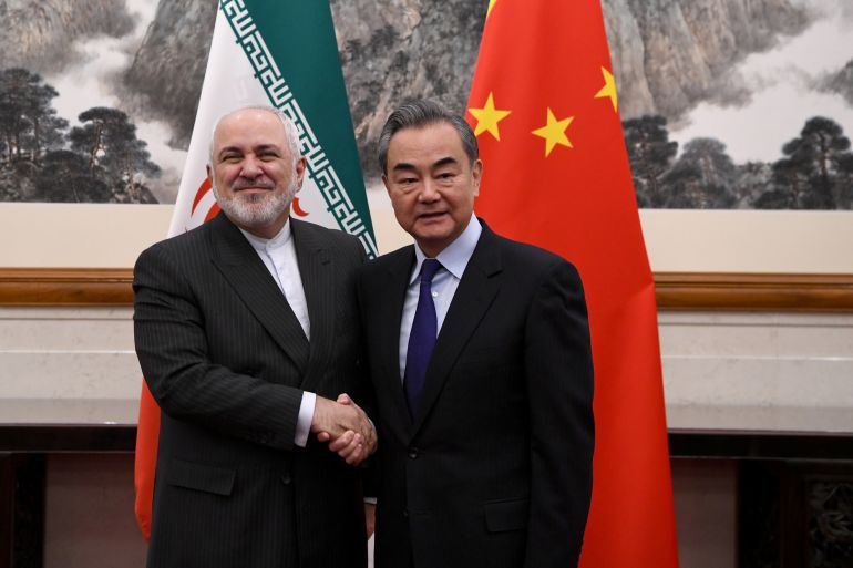 China's Foreign Minister Wang Yi shakes hands with Iran's Foreign Minister Mohammad Javad Zarif during a meeting at the Diaoyutai state guest house in Beijing