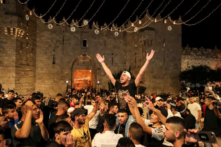 Palestinians celebrate outside Damascus Gate after barriers that were put up by Israeli police are removed, allowing them to access the main square that has been the focus of a week of clashes around Jerusalem's Old City