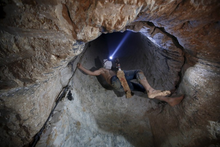 A Palestinian worker is lowered on a rope into a smuggling tunnel, that was flooded by Egyptian security forces, beneath the border between Egypt and southern Gaza Strip
