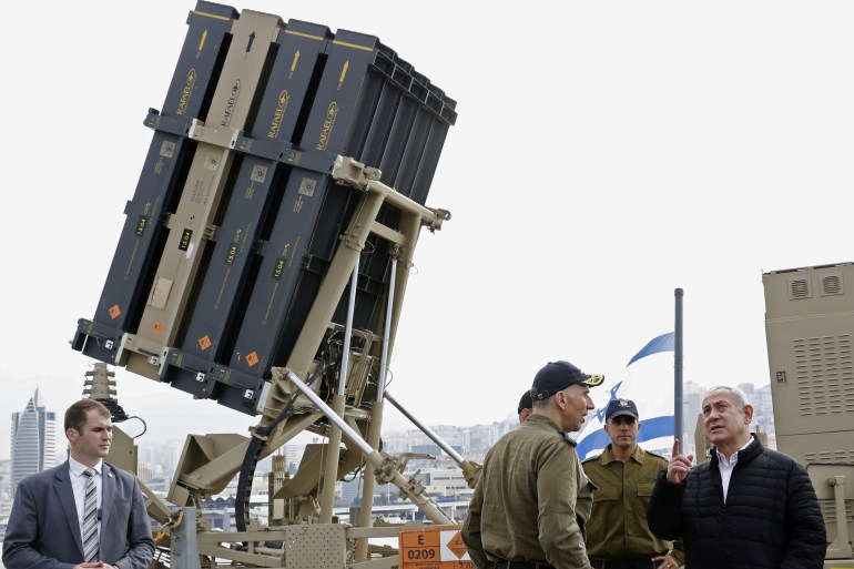 Israeli Prime Minister Benjamin Netanyahu stands near the Iron Dome interceptor system during a tour of a missile boat as part of his visit to a navy base in Haifa
