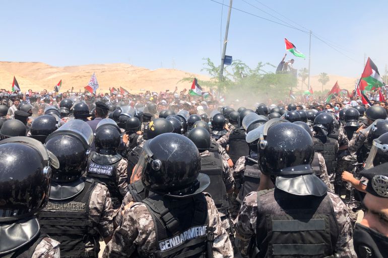 Demonstrators hold Palestinian flags during a protest to express solidarity with the Palestinian people, in Karameh, Jordan valley