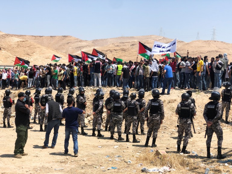 Demonstrators hold Palestinian flags during a protest to express solidarity with the Palestinian people, in Karameh, Jordan valley