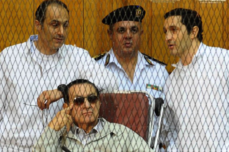 الرئيس المصري الراحل حسني مبارك وسط نجليه علاء (يمين) وجمال أثناء المحاكمة