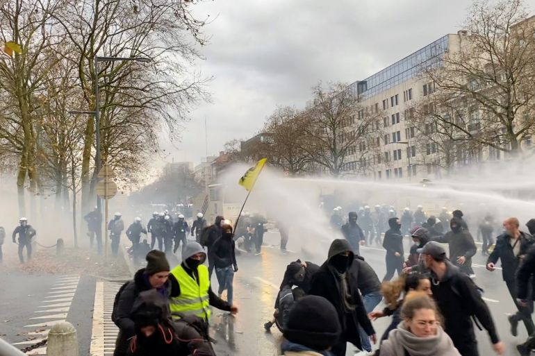 Demonstrators run away from water cannons during a protest, in Brussels, Belgium, November 21, 2021, in this still image obtained from a social media video. Twitter/@jordynuyts/via REUTERS THIS IMAGE HAS BEEN SUPPLIED BY A THIRD PARTY. MANDATORY CREDIT. NO RESALES. NO ARCHIVES.