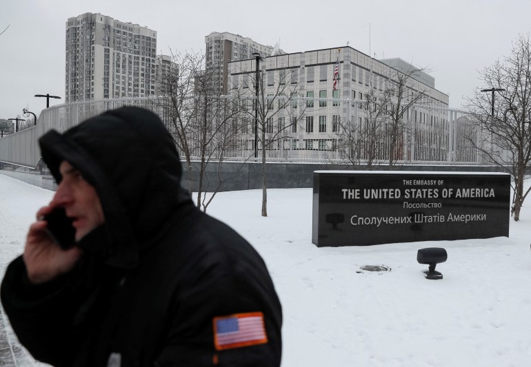 A security guard speaks on the phone outside the U.S. embassy in Kyiv
