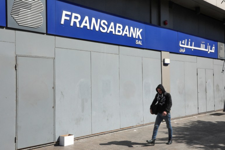 A man walks past fortified branch of Fransabank in Beirut